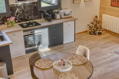 a kitchen with a table and chairs and a christmas tree at chalet Louis situé 25 km Chamonix in Saint-Gervais-les-Bains