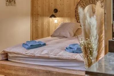 a bed with two blue towels on top of it at chalet Louis situé 25 km Chamonix in Saint-Gervais-les-Bains