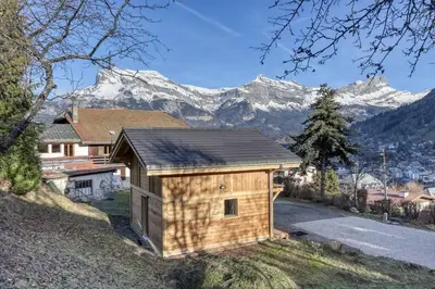 a small wooden building with mountains in the background at chalet Louis situé 25 km Chamonix in Saint-Gervais-les-Bains