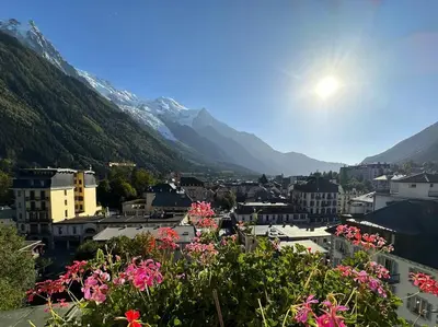 a city with flowers and mountains in the background at Nouveau ! spacieux 100 m², hyper centre Chamonix in Chamonix-Mont-Blanc