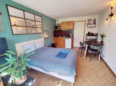 a bedroom with a bed and a kitchen with a table at Apartement vue Monblanc incroyable ski inout Prarion5 in Les Houches