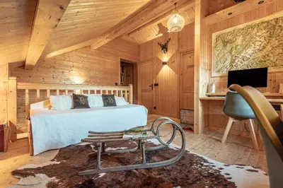a bedroom in a log cabin with a bed and a desk at SmartStay - Chalet face au mont Blanc in Sallanches