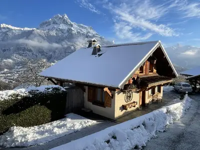 a house covered in snow with a mountain in the background at SmartStay - Chalet face au mont Blanc in Sallanches