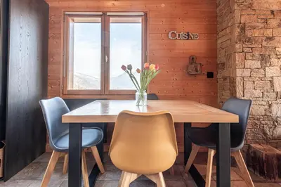 a dining room with a wooden table and chairs at SmartStay - Chalet face au mont Blanc in Sallanches