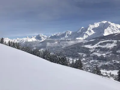 a snow covered mountain range with a town in the distance at SmartStay - Chalet face au mont Blanc in Sallanches