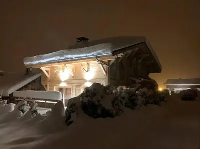 a house covered in snow at night with lights at Individual chalet for up to 12 people maximum in Les Contamines-Montjoie