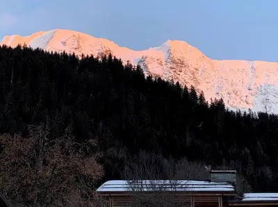 a building in front of a mountain with snow at Individual chalet for up to 12 people maximum in Les Contamines-Montjoie