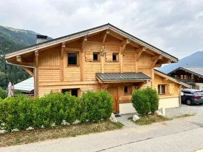 a wooden house with a car parked in front of it at Individual chalet for up to 12 people maximum in Les Contamines-Montjoie