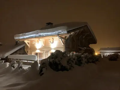 a house covered in snow at night with lights at Individual chalet for up to 12 people maximum in Les Contamines-Montjoie