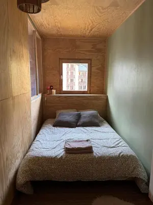 a bed in a small room with a window at L’Atypique - centre Chamonix in Chamonix-Mont-Blanc