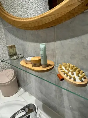 a bathroom with a glass shelf above a sink at L’Atypique - centre Chamonix in Chamonix-Mont-Blanc