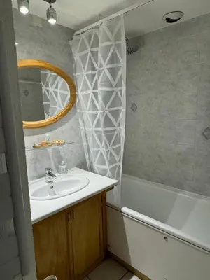 a bathroom with a sink and a tub and a mirror at L’Atypique - centre Chamonix in Chamonix-Mont-Blanc