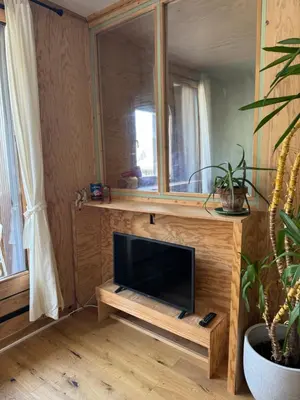 a living room with a television and a mirror at L’Atypique - centre Chamonix in Chamonix-Mont-Blanc