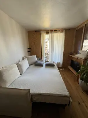 a large bed in a room with a window at L’Atypique - centre Chamonix in Chamonix-Mont-Blanc