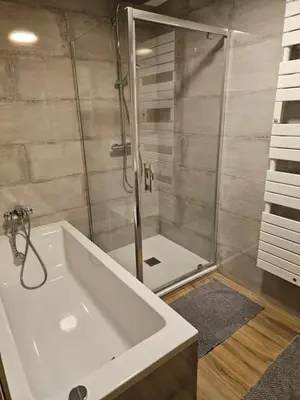 a bathroom with a shower and a white bath tub at Les Fées Mer : appart 150 m² hypercentre calme 10p in Chamonix-Mont-Blanc