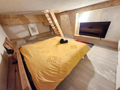 a small bedroom with a yellow bed and a ladder at Les Fées Mer : appart 150 m² hypercentre calme 10p in Chamonix-Mont-Blanc