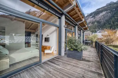 a glass house with a balcony with a bed and a desk at Chalet 124 in Chamonix-Mont-Blanc