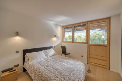 a bedroom with a bed and a desk and a window at Chalet 124 in Chamonix-Mont-Blanc