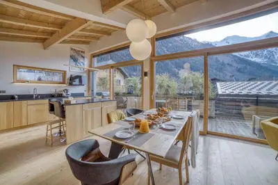 a kitchen and dining room with a table and a large window at Chalet 124 in Chamonix-Mont-Blanc