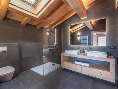 a bathroom with two sinks and a shower and a toilet at Chalet moderne à Combloux avec piscine et espace bien-être - FR-1-569-160 in Combloux