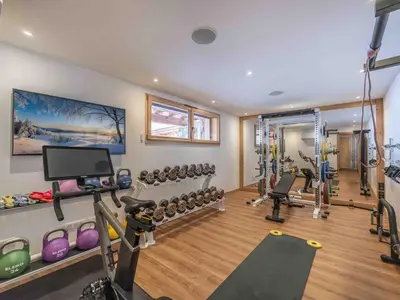a gym with several treadmills and machines in a room at Chalet moderne à Combloux avec piscine et espace bien-être - FR-1-569-160 in Combloux