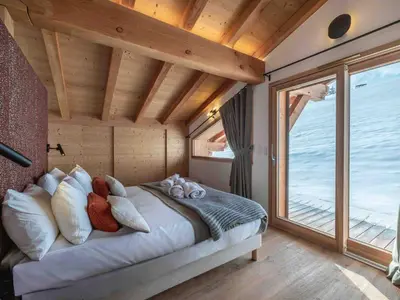 a bed in a room with a large window at Chalet moderne à Combloux avec piscine et espace bien-être - FR-1-569-160 in Combloux