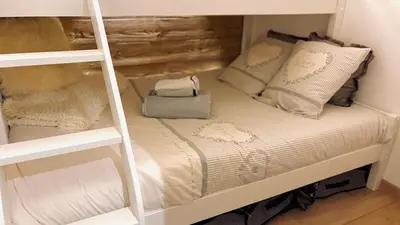 a bunk bed with white sheets and pillows on it at Ski ou Thermes? Un appt cabine avec vue magnifique in Saint-Gervais-les-Bains