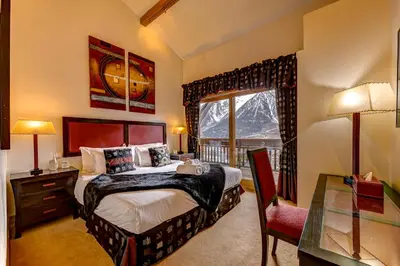 a bedroom with a bed and a window with a mountain at Chalet Serena - luxury 7 Bedroom Chalet, Pool & Spa in Les Houches