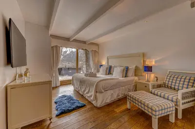 a bedroom with a bed and a couch and a tv at Chalet Serena - luxury 7 Bedroom Chalet, Pool & Spa in Les Houches