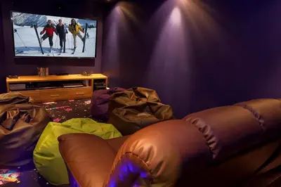 a living room with a couch and a flat screen tv at Chalet Serena - luxury 7 Bedroom Chalet, Pool & Spa in Les Houches