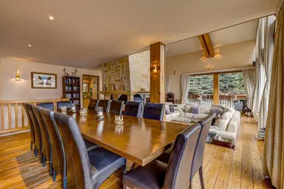 a dining room with a large wooden table and chairs at Chalet Serena - luxury 7 Bedroom Chalet, Pool & Spa in Les Houches