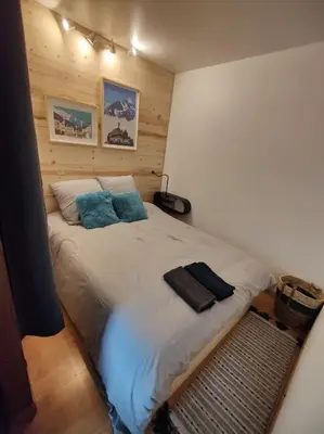 a bedroom with a large bed with blue pillows at Apartement vue montage magnifique 2ch 5mn piste 3 in Les Houches