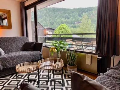 a living room with a couch and chairs and a large window at Apartement vue montage magnifique 2ch 5mn piste 3 in Les Houches