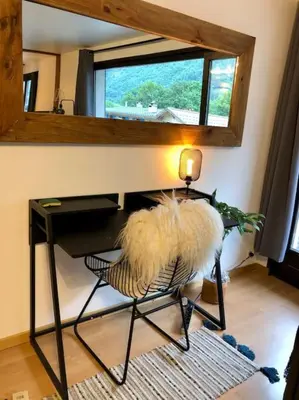 a room with a table and a chair with a mirror at Apartement vue montage magnifique 2ch 5mn piste 3 in Les Houches