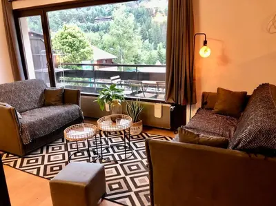 a living room with two couches and a large window at Apartement vue montage magnifique 2ch 5mn piste 3 in Les Houches