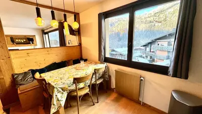 a dining room with a table and a large window at Apartement vue montage magnifique 2ch 5mn piste 3 in Les Houches