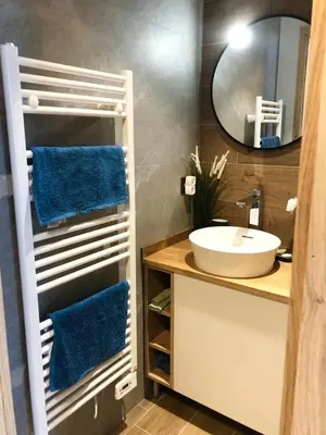 a bathroom with a sink and a mirror and blue towels at Appart Centre Chamonix Grande Terrasse Mont Blanc in Chamonix-Mont-Blanc