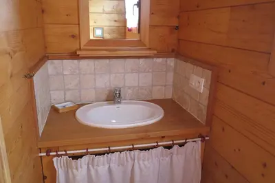 a bathroom with a sink in a wooden cabin at La Planque des Marmottes in Servoz
