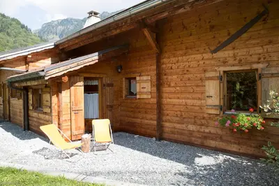 a cabin with two chairs sitting outside of it at La Planque des Marmottes in Servoz