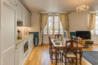 a kitchen with a table and chairs and a television at Apartment Aiguille du Midi Central Chamonix - Alpes Travel - Sleeps 6 in Chamonix-Mont-Blanc
