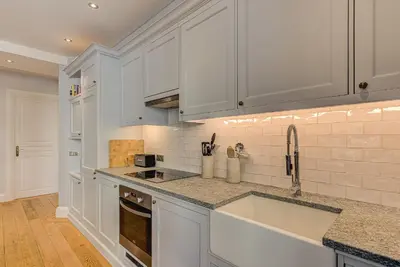 a kitchen with white cabinets and a sink at Apartment Aiguille du Midi Central Chamonix - Alpes Travel - Sleeps 6 in Chamonix-Mont-Blanc