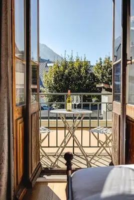 a table with a bottle of wine on a balcony at Apartment Aiguille du Midi Central Chamonix - Alpes Travel - Sleeps 6 in Chamonix-Mont-Blanc