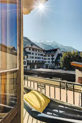 a balcony with a yellow pillow and a view of a building at Apartment Aiguille du Midi Central Chamonix - Alpes Travel - Sleeps 6 in Chamonix-Mont-Blanc
