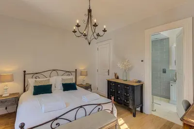 a bedroom with a large bed and a chandelier at Apartment Aiguille du Midi Central Chamonix - Alpes Travel - Sleeps 6 in Chamonix-Mont-Blanc