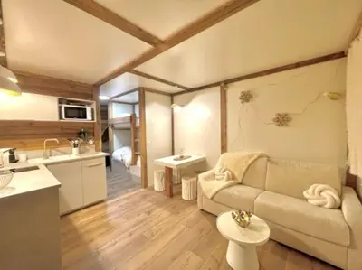 a living room with a couch and a kitchen at Terrasse vue Mont Blanc, centre Chamonix in Chamonix-Mont-Blanc