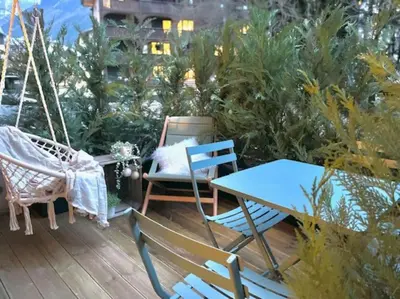 a patio with a hammock and a table and chairs at Terrasse vue Mont Blanc, centre Chamonix in Chamonix-Mont-Blanc
