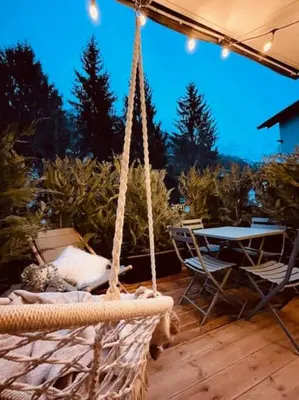 a rope swing with a table and chairs on a patio at Terrasse vue Mont Blanc, centre Chamonix in Chamonix-Mont-Blanc