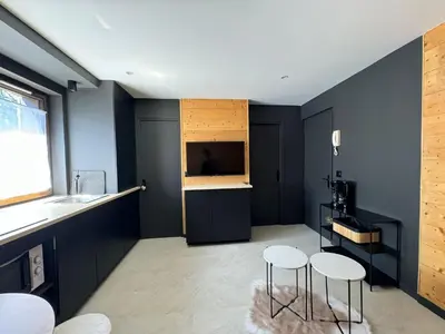 a room with two stools and a kitchen with blue walls at Appartement F2 Bis centre de Megève in Megève