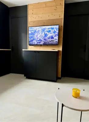 a tv on a wall in a room with a table at Appartement F2 Bis centre de Megève in Megève