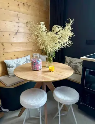a wooden table with two stools and a vase of flowers at Appartement F2 Bis centre de Megève in Megève